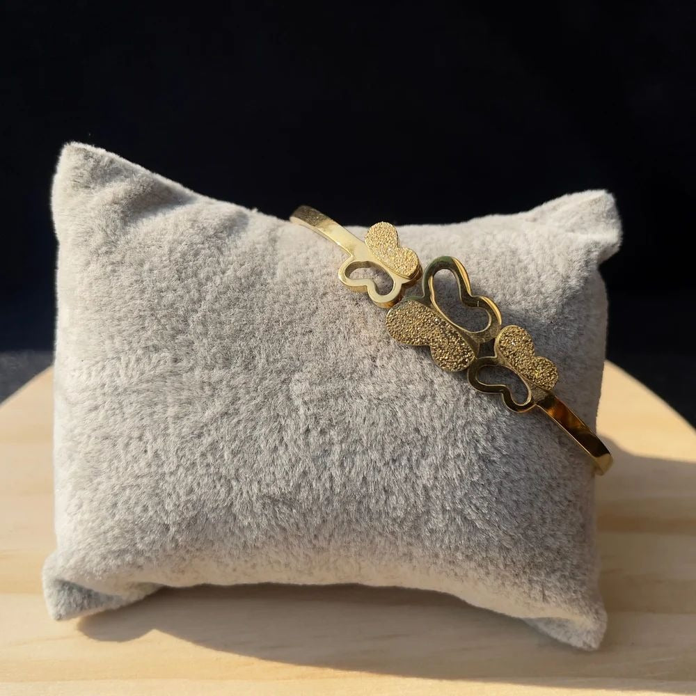 Side angle of Triple Butterfly Bracelet on cushion