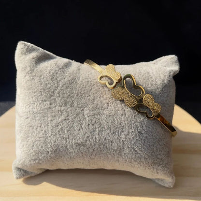 Side angle of Triple Butterfly Bracelet on cushion