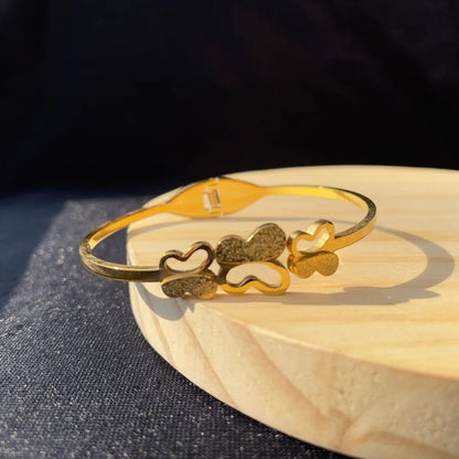 Close-up of the gold butterfly charms on bracelet