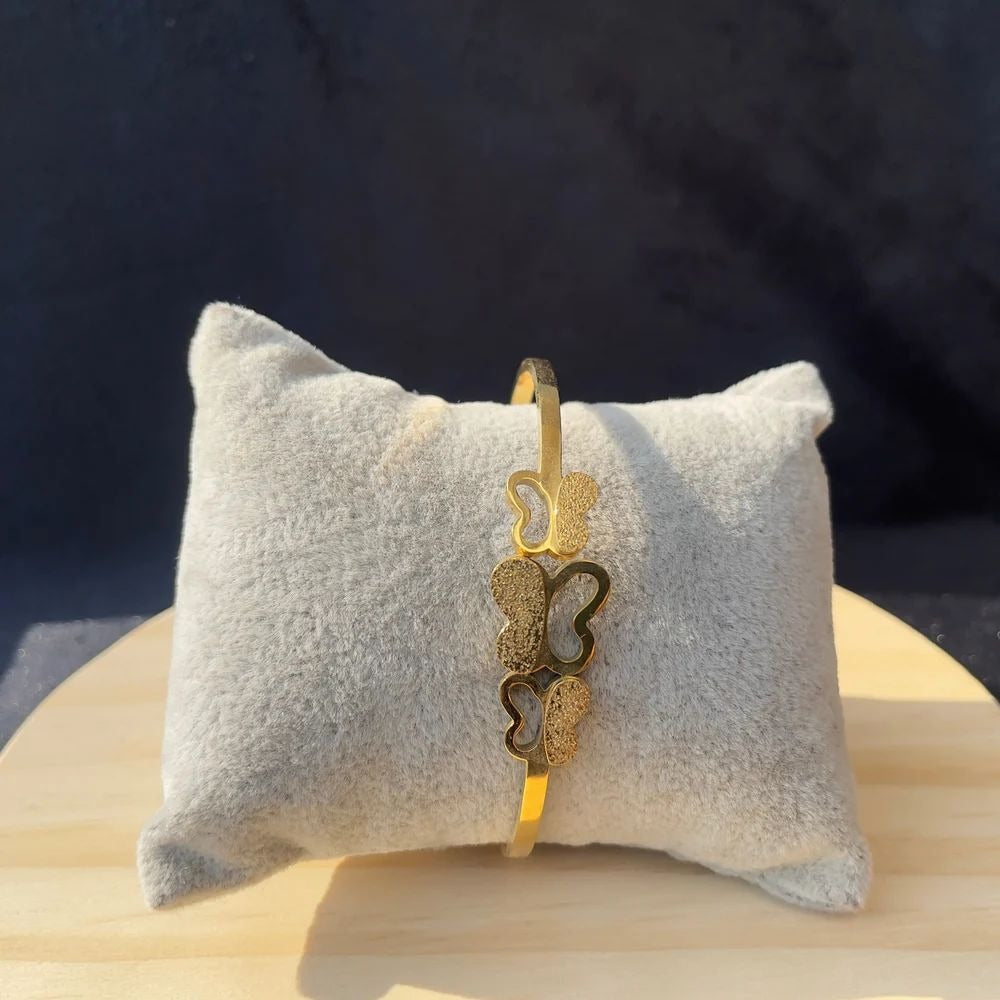 Triple Butterfly Bangle on soft grey cushion – vertical front display