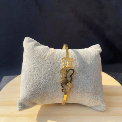Triple Butterfly Bangle on soft grey cushion – vertical front display