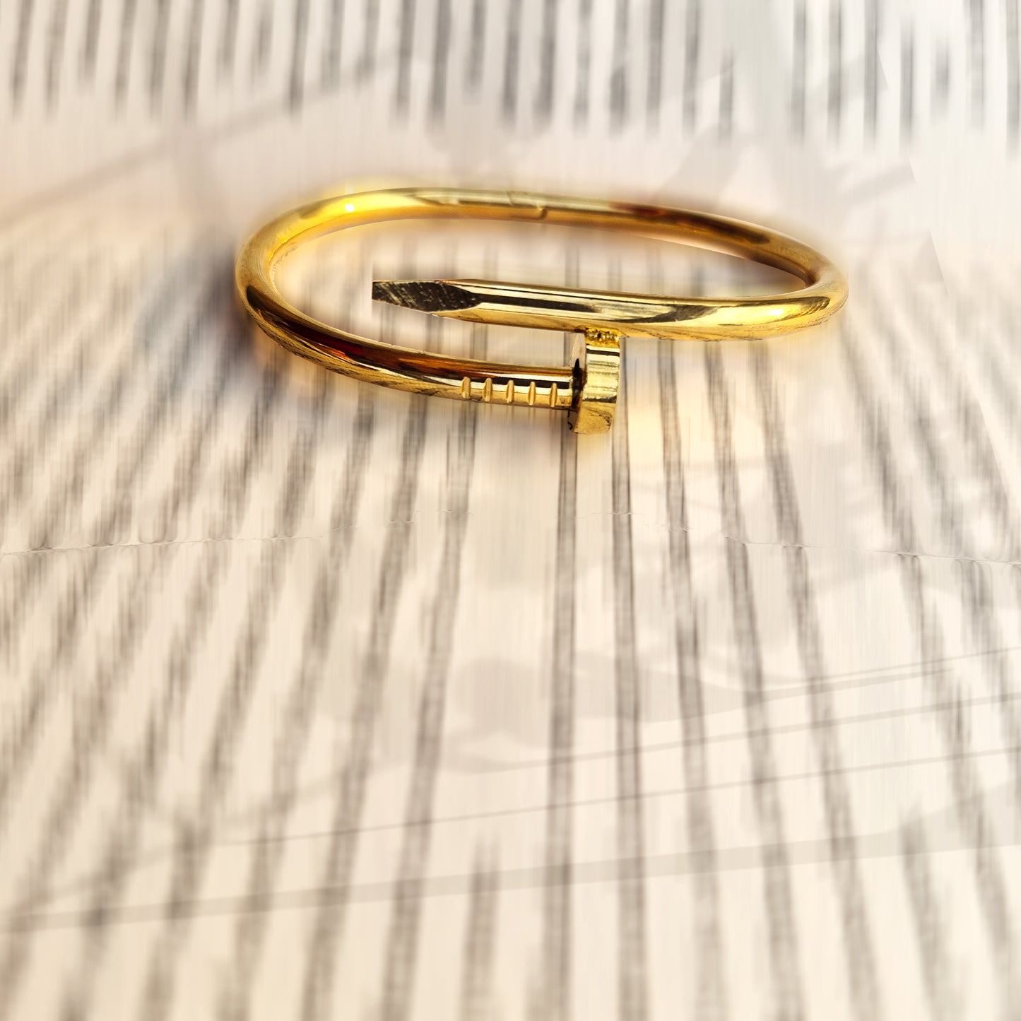 Close-up detail of the nail head and pointed tip on the gold urban bangle.