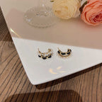 Pearl and gold-accent black velvet earrings styled with wine glass and roses