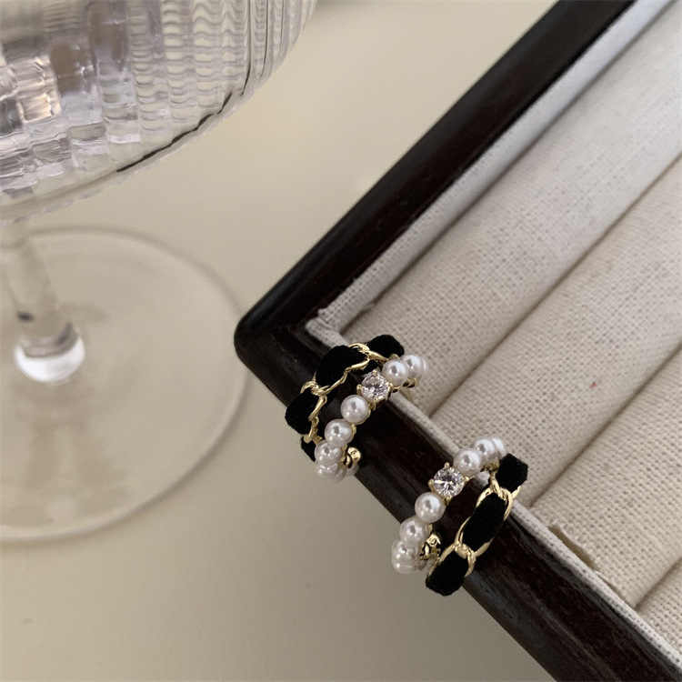 Close-up of black velvet pearl hoop earrings on a fabric jewelry tray
