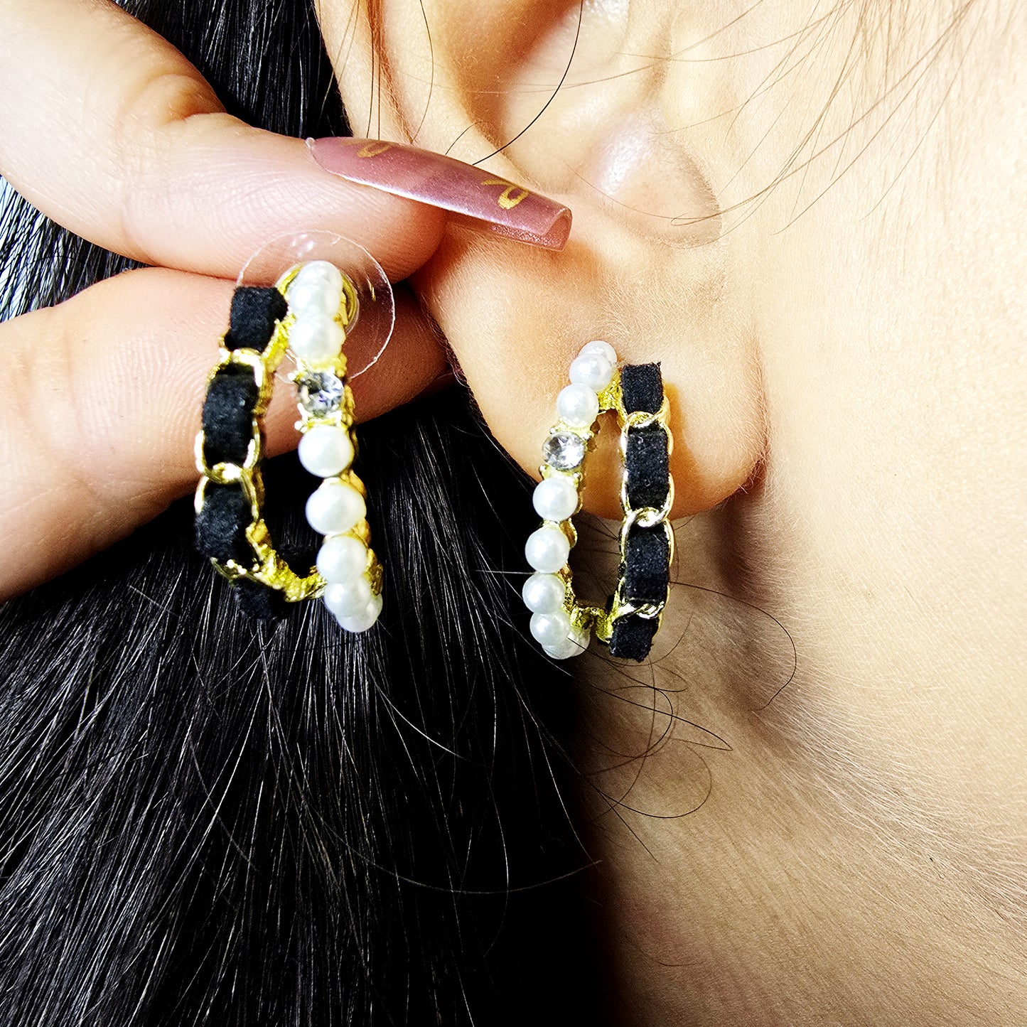 Close-up of model wearing Velvet Pearl Earrings—black velvet hoops with pearls and crystal accents