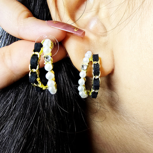 Close-up of model wearing Velvet Pearl Earrings—black velvet hoops with pearls and crystal accents