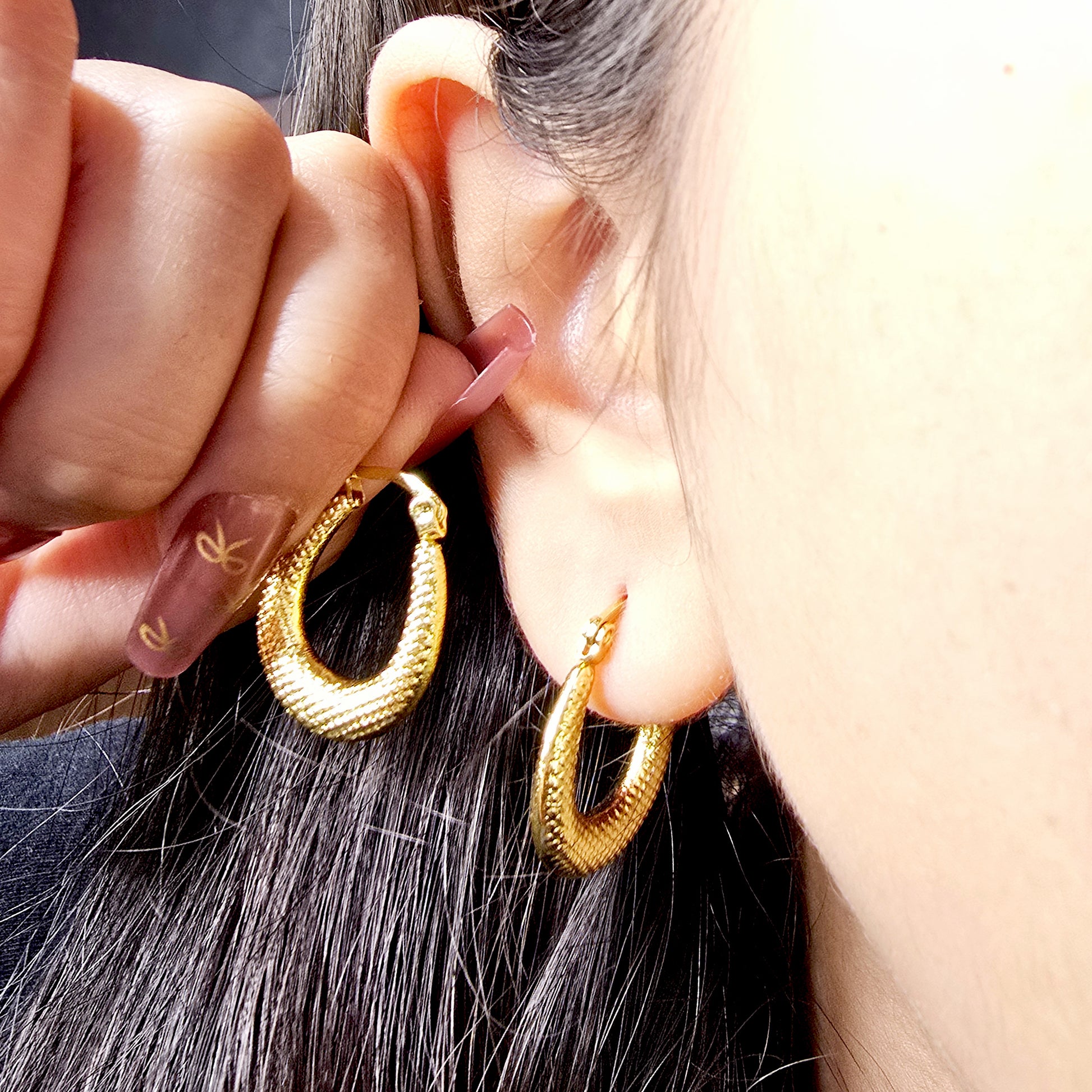 Model wearing textured vintage crescent hoop earrings in gold
