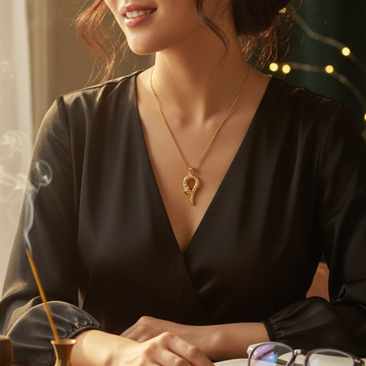 Model wearing the statement gold viper pendant necklace against a dark top, highlighting the dramatic drop.