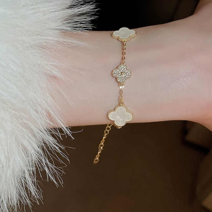 White clover charm bracelet worn on wrist with fur sleeve