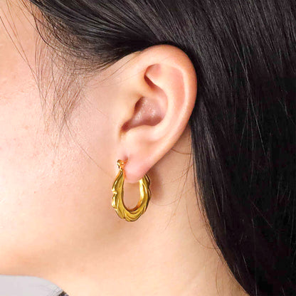 Zigzag Hoop Earrings – close-up of model wearing bold textured gold hoops