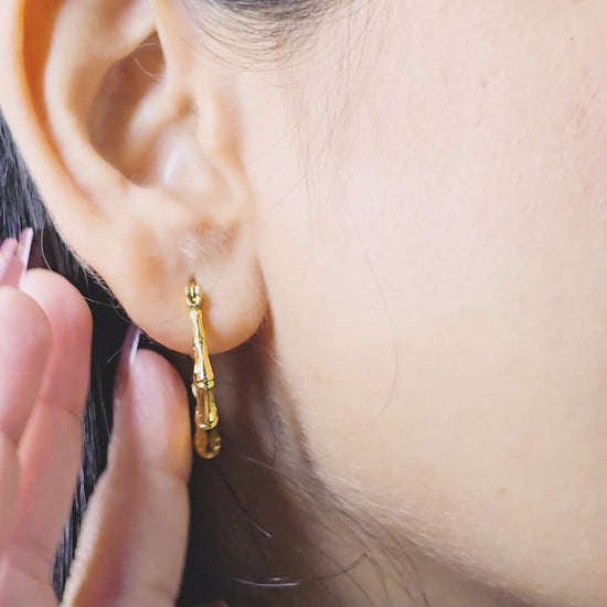 Bamboo Luxe Earrings – close-up video of bold gold bamboo-inspired textured hoops worn on model’s ear, highlighting glossy anti-tarnish finish and statement design.