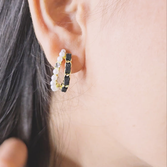 Model wearing Velvet Pearl Earrings—black velvet and pearl-accented gold hoops, close-up side profile view.