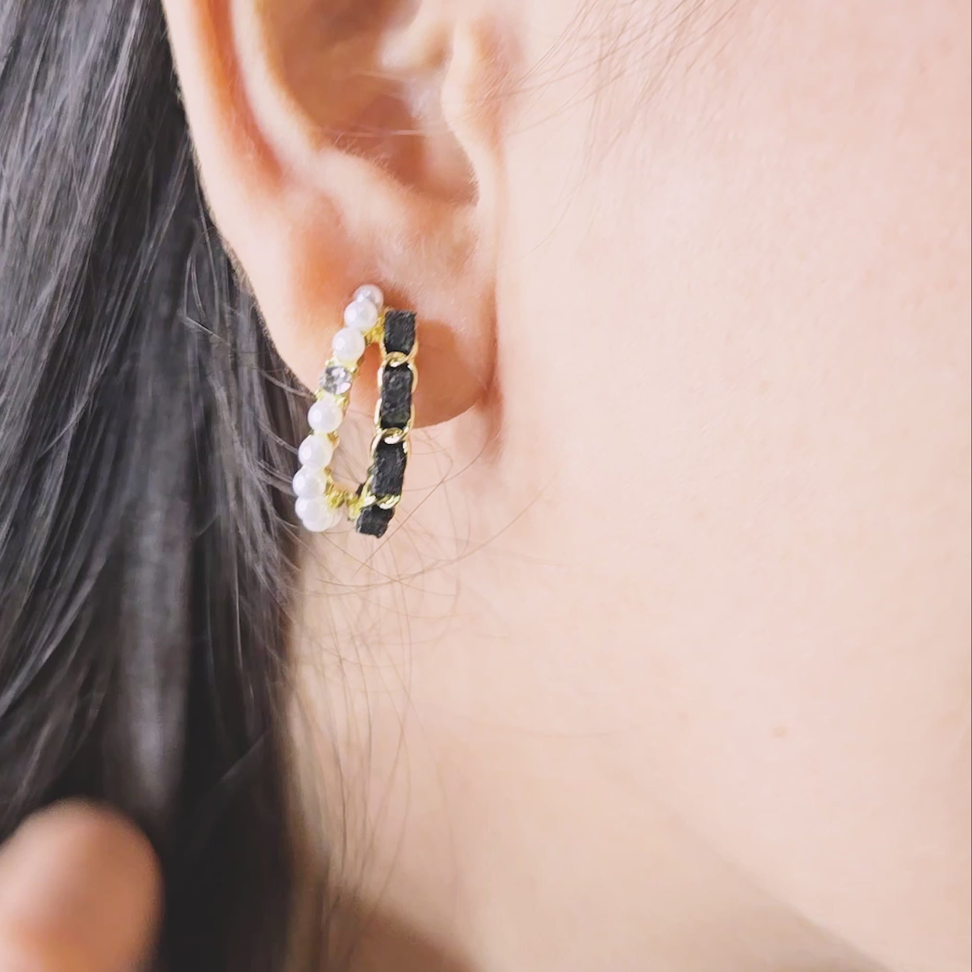 Model wearing Velvet Pearl Earrings—black velvet and pearl-accented gold hoops, close-up side profile view.