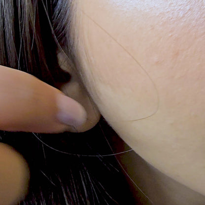 A detailed view of the model wearing only the Etched Heart studs from the 3-in-1 set. The camera focuses on the intricate, wavy etched pattern on the heart's surface, demonstrating its use as a sophisticated, everyday minimalist accessory.