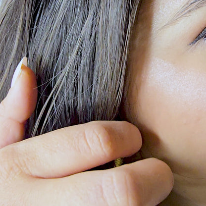 Close-up video showing the brilliant gold shine and secure fit of the striped heart earrings on a model.