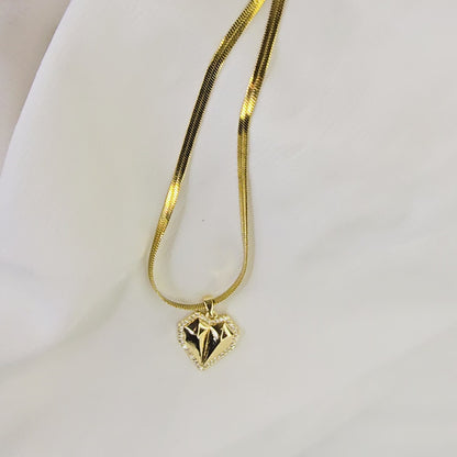 Video showing the 3D form, faceted surface, and movement of the gold-plated geometric heart pendant on a herringbone chain.