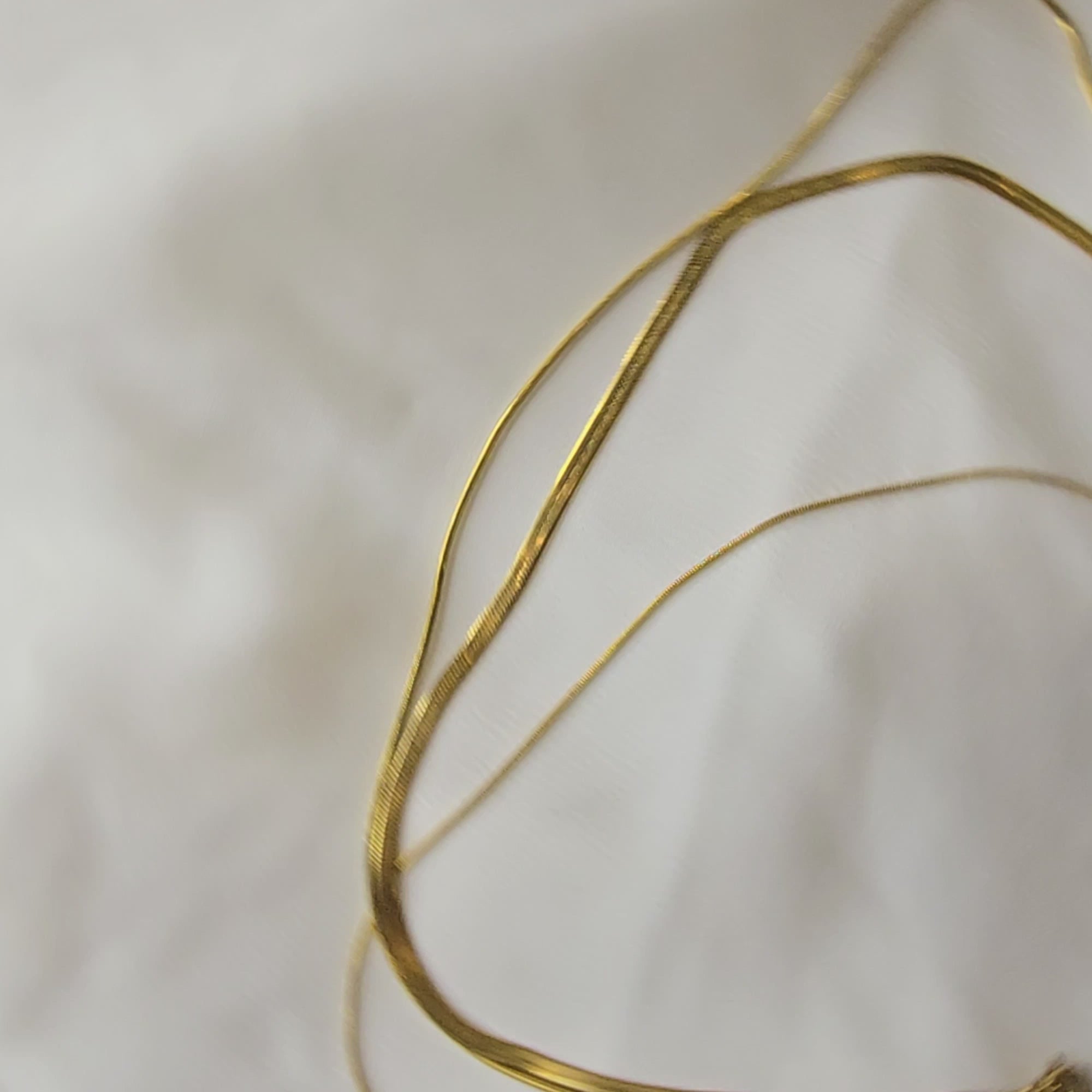 360-degree video of Trinity Layers Necklace showcasing its three delicate gold-toned chains with layered design, smooth finish, and elegant drape from all angles.