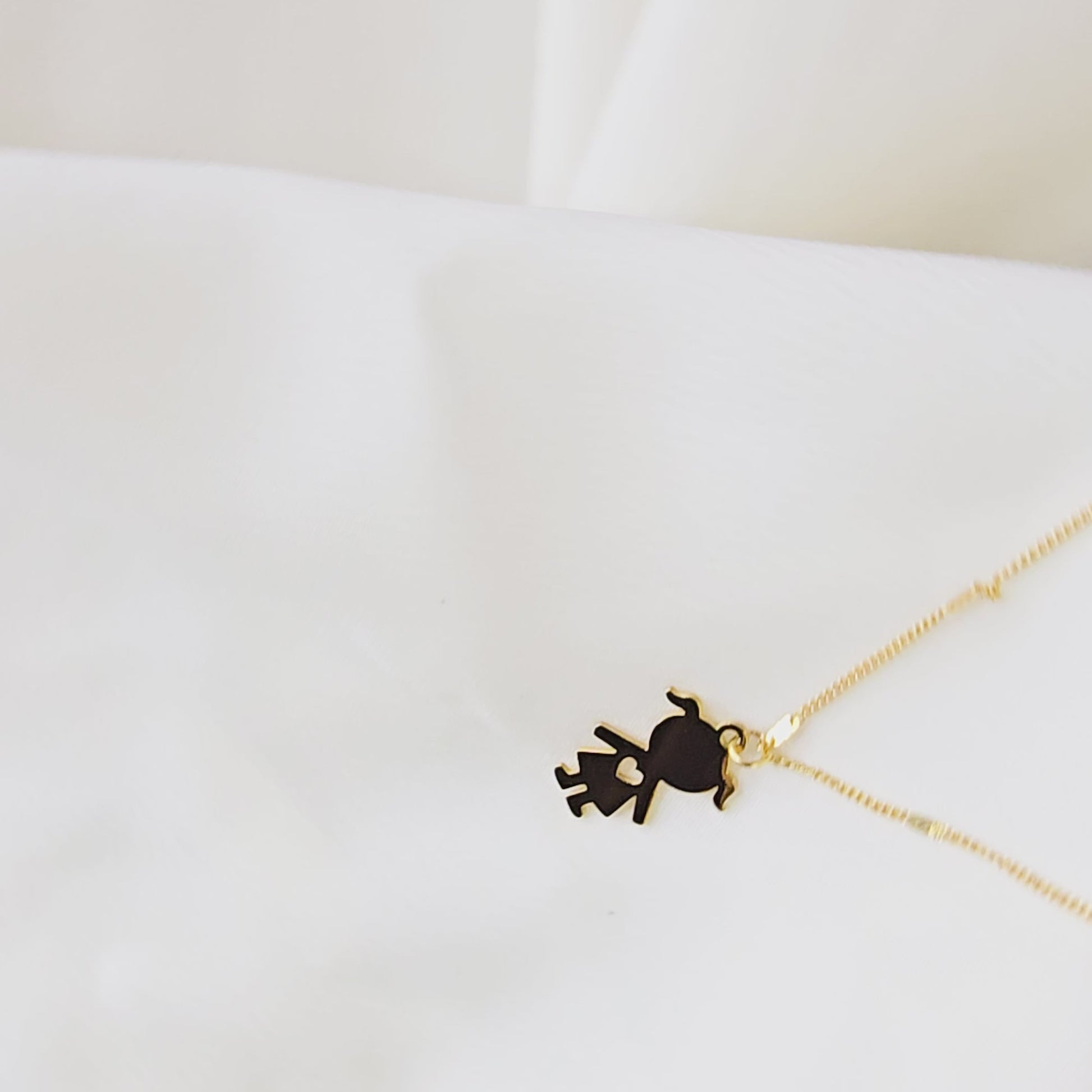 Video showing the detail and movement of the gold-plated little girl silhouette pendant and chain.