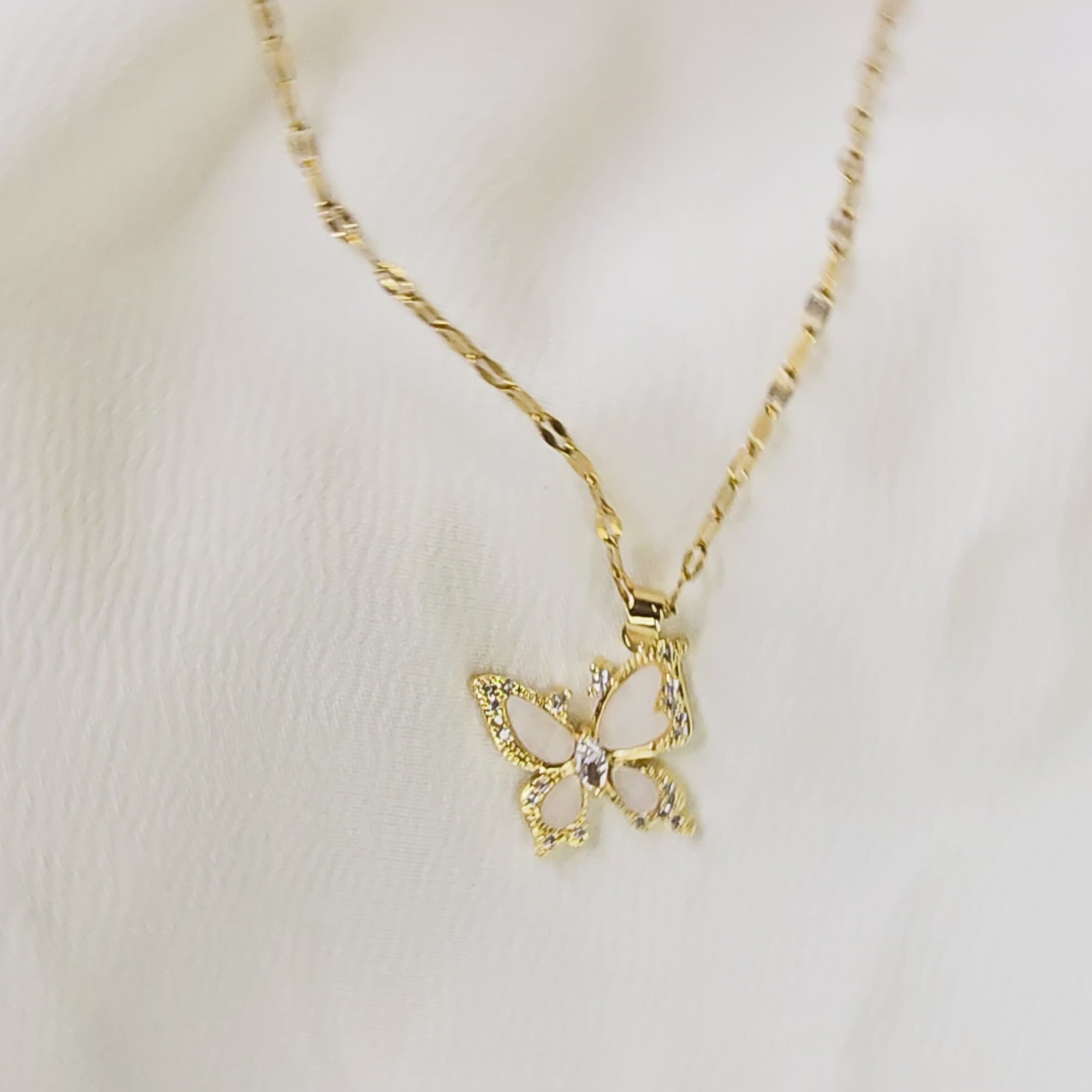 360-degree video of Crystal Butterfly Pendant Chain on white background, showing gold-toned necklace with sparkling crystal butterfly pendant and enamel detailing.