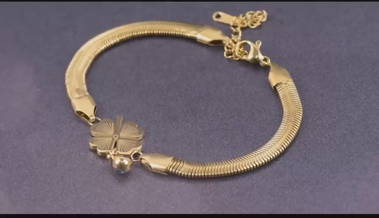 Video showcasing the Clover Charm Snake Chain Bracelet with 360° rotation and close-up views. Features glossy gold snake chain and delicate white clover charms, highlighting its minimalist, waterproof, and anti-tarnish finish.