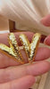 Gold textured V-shaped stud earrings on stone backdrop – bold, waterproof, anti-tarnish statement jewelry by Zunari Charm