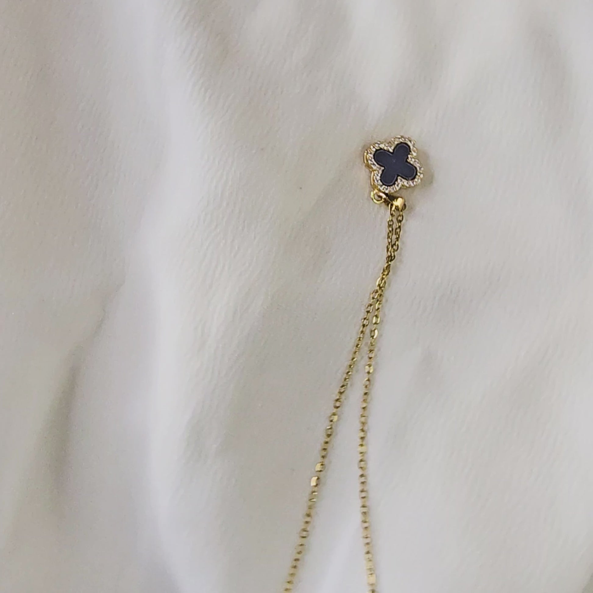 Video demonstrating the reversible feature and the different finishes (solid gold and crystal pavé) of the clover pendant.