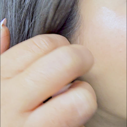 Close-up video showing the light-reflecting sunburst pattern and secure fit of the gold Nova Coin studs on a model.