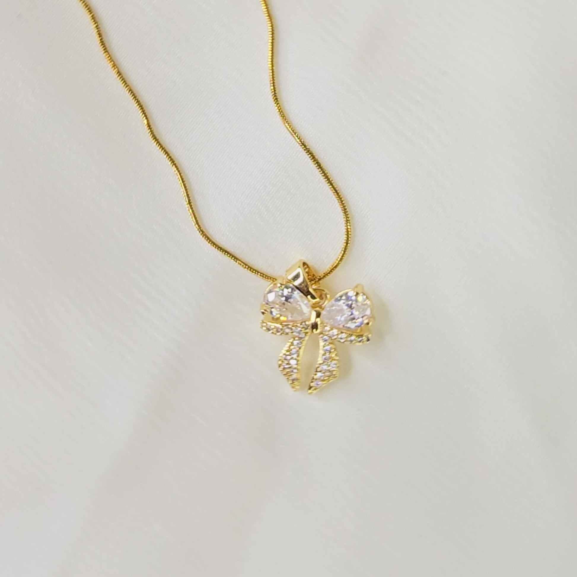360-degree video of AD Bow Necklace showing pendant details and sparkle under light.
