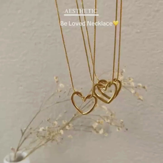 Video showcasing the Twisted Heart Necklace in motion — close-up views of the gold-toned sculpted heart pendant, snake chain shine, and adjustable clasp detail on a neutral background