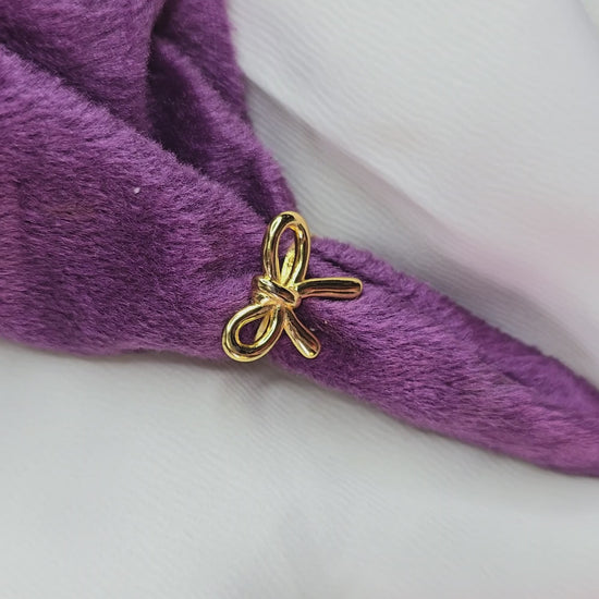 360-degree product video of a gold bow knot ring from Zunari Charm, rotating on a display table. The video highlights the delicate ribbon bow design, polished finish, and elegant shine, showcasing its chic and feminine style.