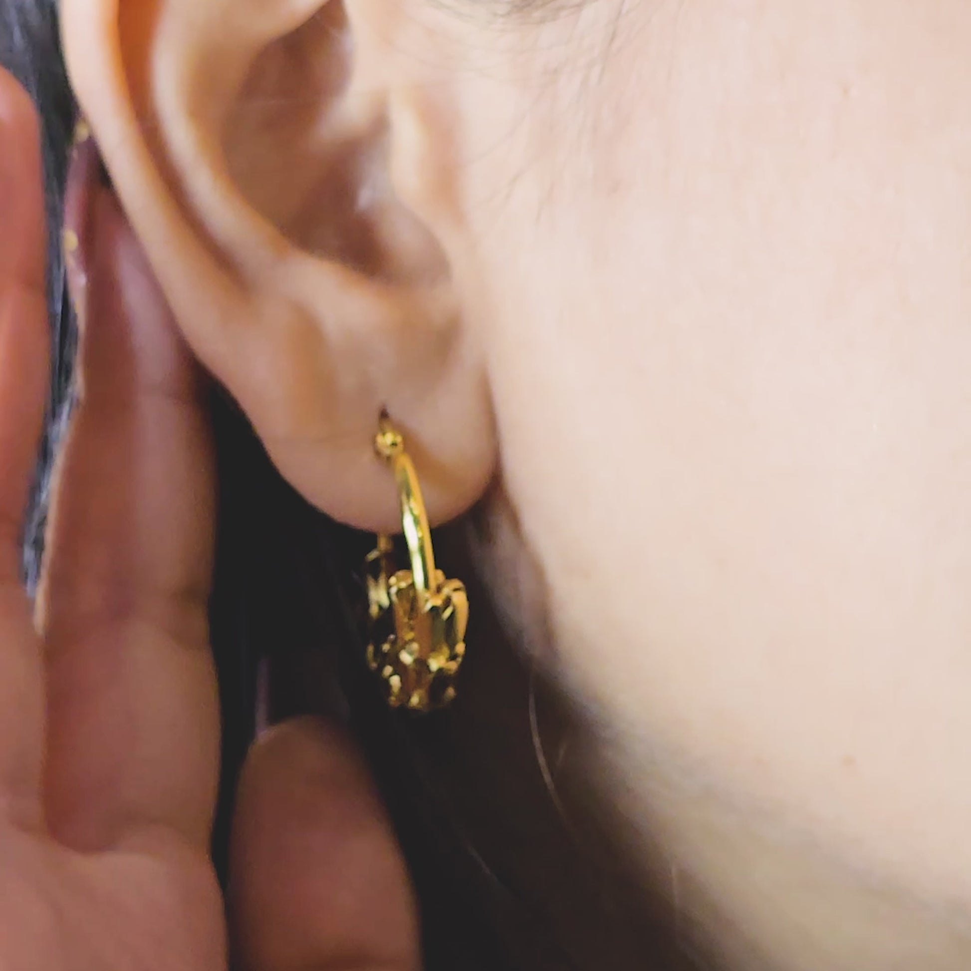Snake Scale Earrings – close-up video of gold textured hoop earrings with serpent-inspired scale pattern, worn on model’s ear to highlight anti-tarnish waterproof finish and bold statement look.