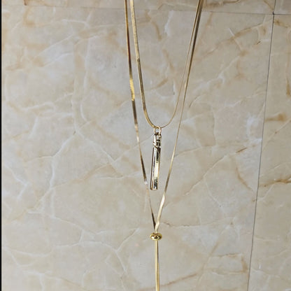 Video showing Layered Charm Drop Necklace from top to bottom, focusing on gold-toned layered chains, bar pendant, and coin drop charms with close-up detailing.