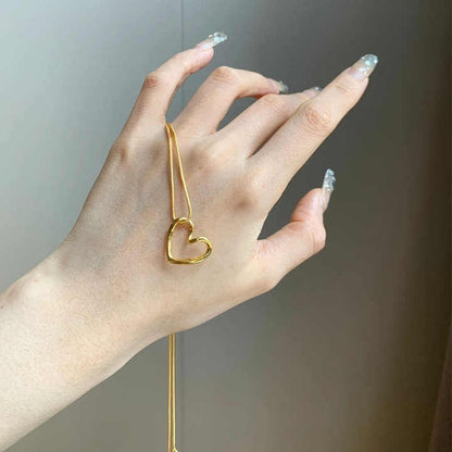 Twisted Heart Necklace shown on hand – lightweight gold pendant with soft curve design