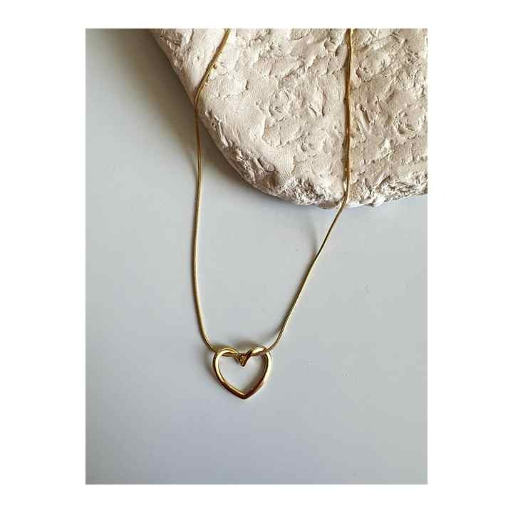 Minimalist Twisted Heart Necklace with full gold chain styled over a neutral-toned stone