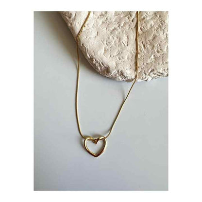 Minimalist Twisted Heart Necklace with full gold chain styled over a neutral-toned stone