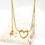 Close-up of Twisted Heart Necklace hanging – gold heart pendant with snake chain and adjustable clasp