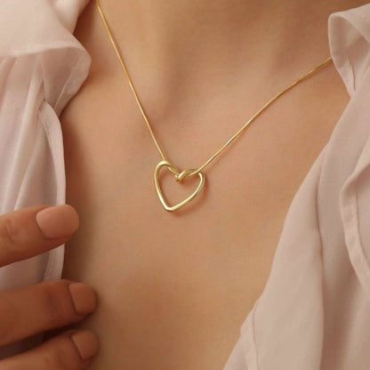 Model wearing the Twisted Heart Necklace – minimalist gold heart pendant resting on collarbone